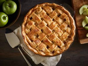 apple pie on a dark wood surface with apples 